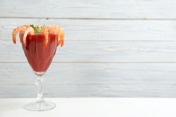 Shrimp cocktail with tomato sauce on white table. Space for text