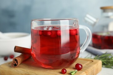 Tasty hot cranberry tea and fresh ingredients on white table