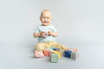 Toddler playing with silicone pastel colored cubes, blocks. Montessori material for fine motor...