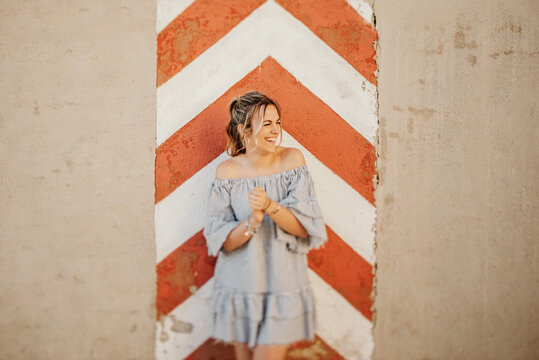 Happy woman laughing against shabby wall