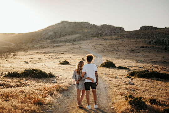 Anonymous couple standing on footpath in evening