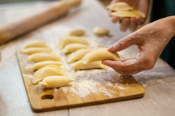 Traditional dish dumplings small pies with cottage cheese on a cutting board