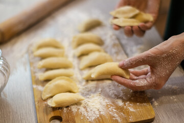 Traditional dish dumplings small pies with cottage cheese on a cutting board