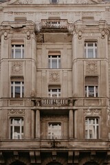 Facade of a building. Beige color, white windows. Urban architecture. with balcony and beautiful decoration. 