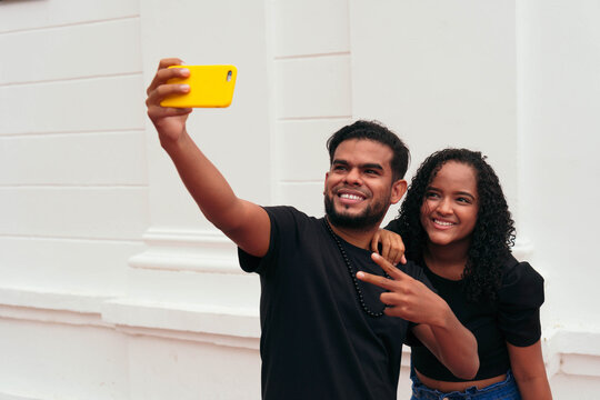 Cheerful Ethnic Couple Taking Selfie On Smartphone In City