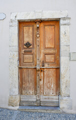 Old shabby door from outside in Arreau town, France. Vintage french architecture