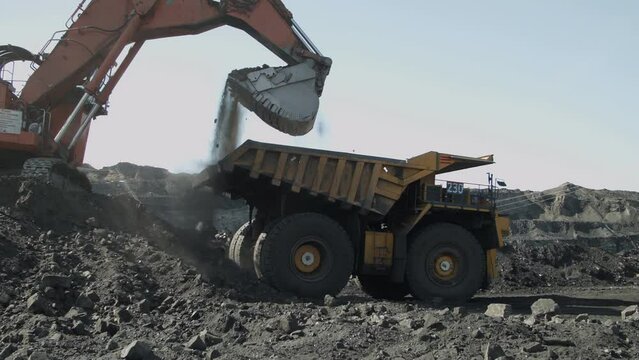 Backhoe loader loading dumper truck