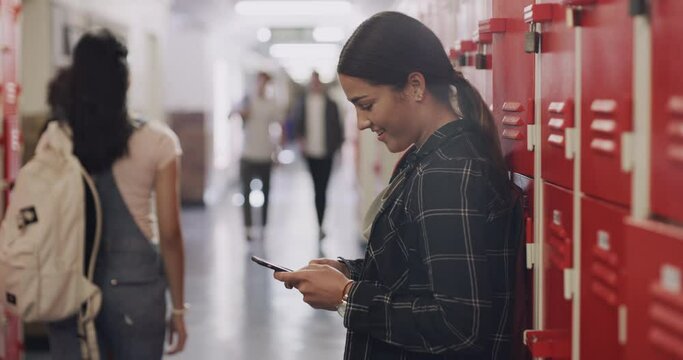 Student teenager on a phone with social media and reading funny online meme next to her locker at high school. Girl browsing the web or internet with a 5g mobile smartphone at an education institute