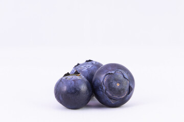 Selective focus, closeup of fresh blueberries against white background