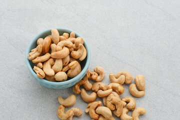 Cashew Nut, in Indonesia known as Kacang Mete. Served in a small bowl on grey background. 