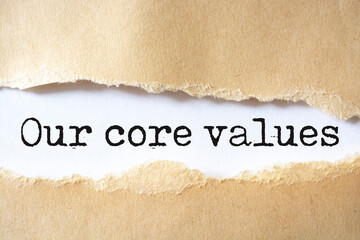 Our core values symbol. Words 'Our core values' appearing behind torn brown paper.
