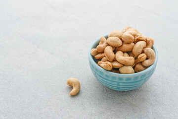 Cashew Nut, in Indonesia known as Kacang Mete. Served in a small bowl on grey background. 