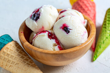 Vanilla ice cream with berry sauce close up.