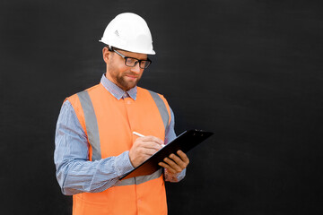 Male Engineer in a White Hard Hats and Orange West. Handsome Confident Build Worker Isolated on Blank Black Background. Copy Space. He Work in a Heavy Industry Manufacturing Factory. Mechanic Service