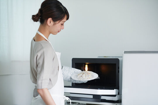 電子レンジを使う女性