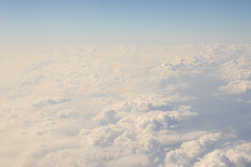 Fototapeta na wymiar photo from airplane fluffy white beautiful clouds heaven window view.aircraft over the clouds horizon line blue sky.vacation travel concept,fly book ticket.airplane wing.sea destination