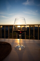 Glass of red wine in the evening sun, wine still in the glass