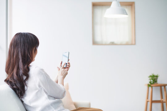 ソファに座る女性スマートフォンと女性