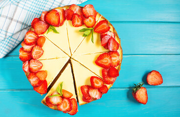 Sweet breakfast, delicious cheesecake with fresh strawberries, homemade recipe on blue wooden table.