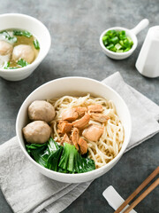 Mie ayam or bakmi ayam is a common Indonesian dish of seasoned yellow wheat noodles topped with diced chicken. Served in a white bowl.