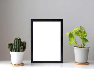 Blank photo frames mockup on the white color desk with pot of plants. Home decoration in minimal style