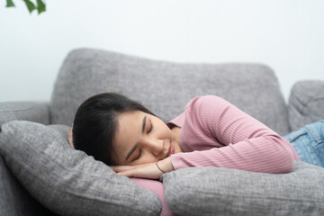 Young asian woman sleeping on sofa at home