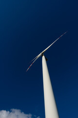 White blades of a wind turbine against the background of a navy blue sky. Renewable energy sources in the decarbonisation process.