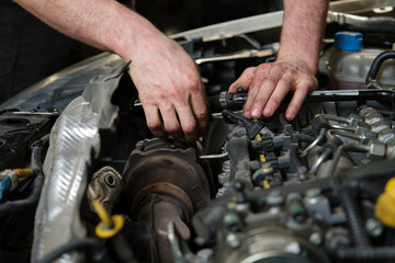 Close up of car mechanic hands doing car service and maintenance. Mechanics workshop.