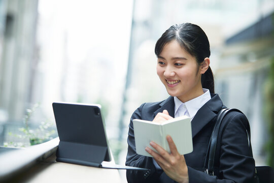 スーツを着て手帳を持つ若い女性