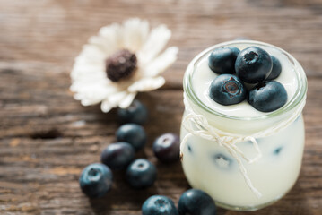 yogurt with fresh blueberry on a wooden background. healthy cereal morning breakfast.