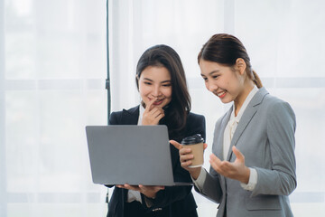Two asian business woman work together to get the job done at the office.