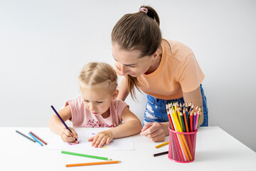 The teacher looks like a child girl draws with colored pencils on paper