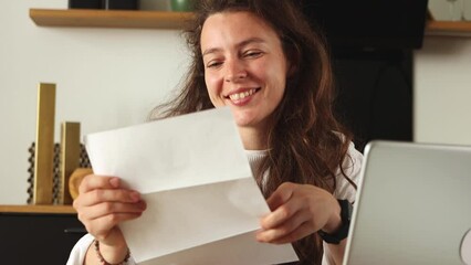Happy attrective caucasian girl student reading good news in paper mail admission letter sitting at home. Feel excited of getting event invitation or university admission. Receiving job offer concept