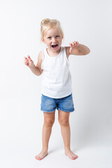 Child in a T-shirt, shorts standing in the studio on a light background