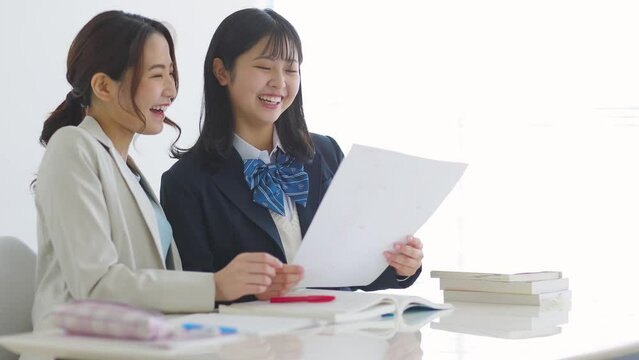 塾でテストの結果を喜ぶ女子学生 高校生 中学生