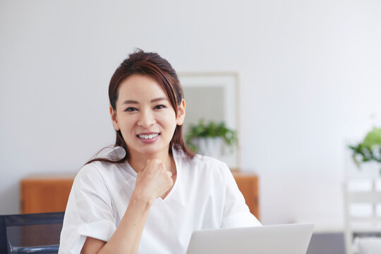 ノートパソコンを使い部屋で仕事をする女性