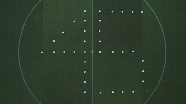 The figure 45 is laid out of footballs on the lawn of a football stadium