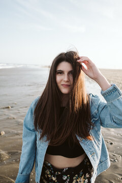 Woman in denim jacket at beach