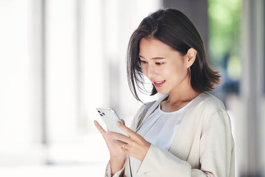 屋外でスマホを持つ若い女性