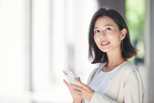 屋外でスマホを持つ若い女性