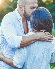 Portrait of a Smiling  happy Couple Kissing    in a Vineyard toasting wine. Beautiful  brunette woman and bearded muscular man spending time together during grape harvest.