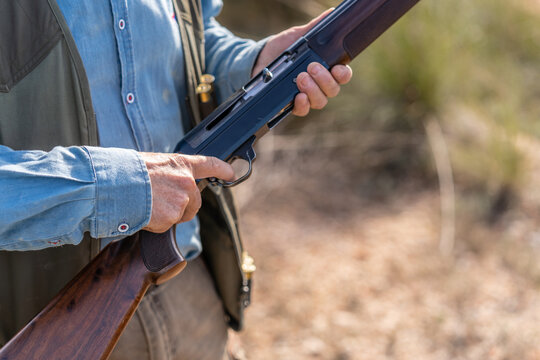 Anonymous huntsman loading rifle in nature