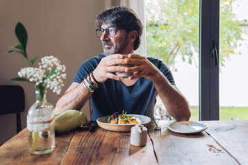 Middle aged man having breakfast in kitchen