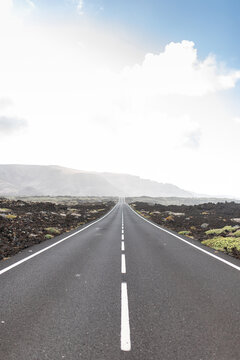 Straight asphalt roadway in mountainous valley