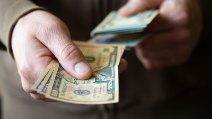 White man giving several dollar bills closeup