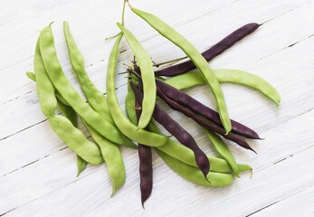 Row of green beans on old wooden background. view from above.