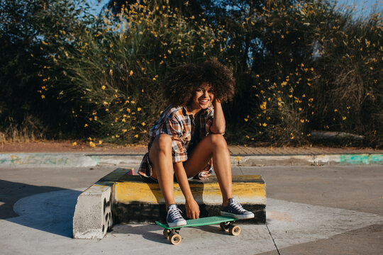 Tranquil African American woman with penny board on street