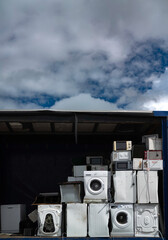  Old broken washing machines and other old electric appliances pilled up on a truck container, pile of electronic waste,