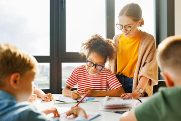 Teacher helping children with schoolwork