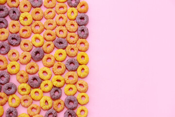 multicolored corn rings for children's breakfast on a pink background, with a place for the text